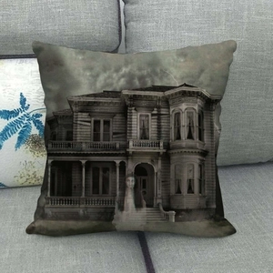 Detail of gothic Halloween pillowcase featuring a haunted house and ghost on a sofa
