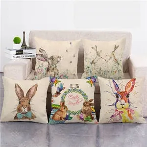 Detail of five linen Easter pillowcases featuring colorful bunny prints on a sofa