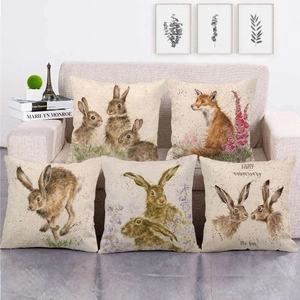 Detail von fünf Leinen-Kissenbezügen mit Aquarell-Hasen und Füchsen auf dem Sofa