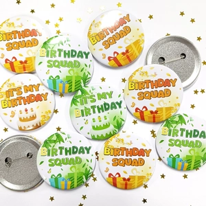 Detailed close-up of birthday tinplate badges with squad lettering and metal safety pins