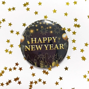 Black and gold Happy New Year tinplate badge with festive fireworks and city skyline decor