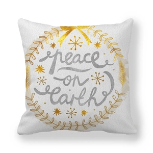 Close-up of peach skin pillowcase featuring peace on earth text and gold leaf wreath