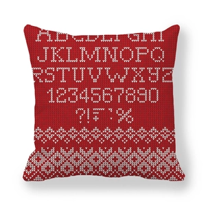 Detail of red knit pillowcase featuring a white woven alphabet and number pattern