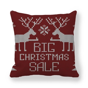 Detail of red Christmas reindeer pillow cover featuring festive white knit patterns