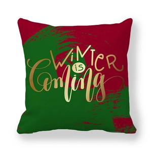 Vue détaillée de la housse de coussin avec texte doré Winter is Coming sur fond de Noël