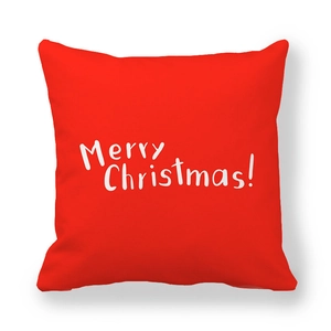 Close-up of red square pillowcase with white Merry Christmas handwriting on soft fabric