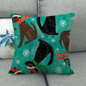 Detail of Christmas dog themed linen pillow cover with festive scarves on a grey sofa