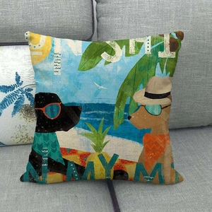 Close-up of tropical Christmas dog print on a linen cushion cover on a grey sofa