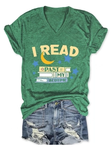 Flat lay of a green V-neck T-shirt with I Read Past My Bedtime print and denim shorts