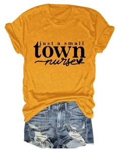Flat lay of mustard yellow nurse t-shirt with heart graphic and distressed denim shorts