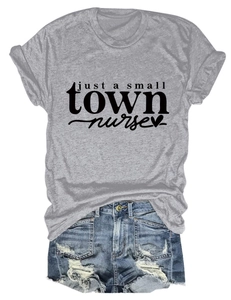 Flat lay of gray nurse graphic t-shirt paired with distressed denim shorts on white background