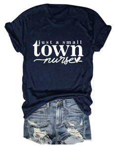 Flat lay of navy Just a Small Town Nurse T-shirt with denim shorts on white background