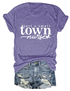 Flat lay of purple nurse t-shirt with heart graphic and distressed blue denim shorts