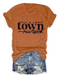 Close-up of rust orange nurse slogan t-shirt paired with ripped denim shorts