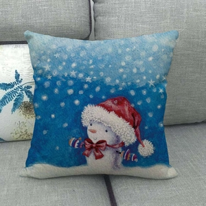 Detail of linen Christmas pillowcase featuring a snowman with hat on a grey sofa