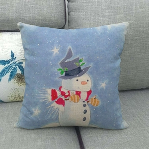 Detail of a Christmas snowman linen pillowcase on a sofa with star and snowflake patterns