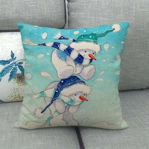Detailed close-up of linen pillowcase with blue cartoon snowman pattern on a gray sofa