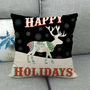 Close-up of linen Christmas pillow cover with white deer design on gray fabric sofa