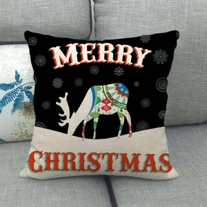 Close-up of linen Christmas reindeer pillowcase with Merry Christmas text on a sofa