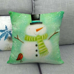 Close-up of linen pillowcase fabric with snowman and robin embroidery on a sofa