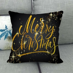 Détail d'une housse de coussin en lin noir avec imprimé doré Joyeux Noël pour canapé