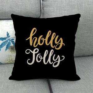 Détail de la housse de coussin de Noël Holly Jolly en lin sur un canapé gris chic