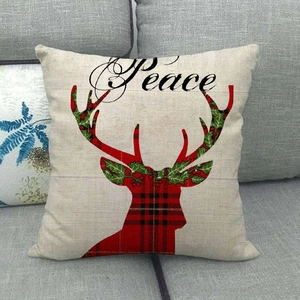 Close-up of linen Christmas pillow case featuring red plaid reindeer and Peace lettering