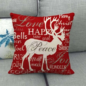 Detail of red linen Christmas pillow cover with white reindeer silhouette and holiday text