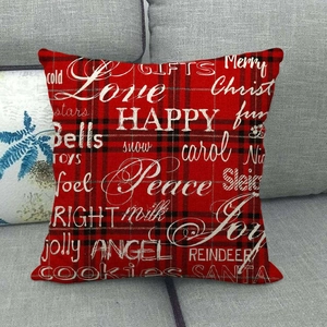 Close-up of red plaid Christmas pillowcase with holiday greetings on a gray sofa