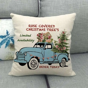 Linen Christmas pillow case featuring vintage blue truck and roses on a gray sofa