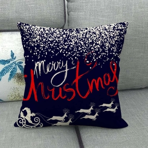 Close-up of linen Christmas pillow case with Merry Christmas text on a grey sofa