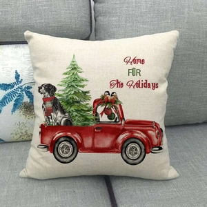 Christmas truck linen pillowcase with dog and festive tree on a grey sofa background