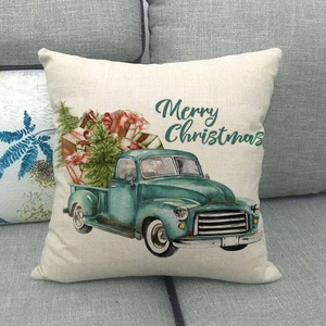 Linen Christmas pillow case with retro green truck and tree on a gray sofa