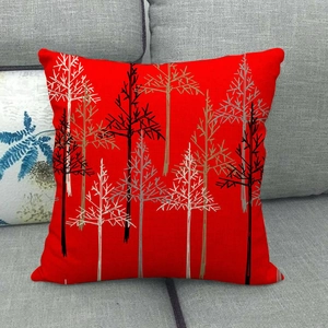 Macro view of red linen pillowcase featuring abstract Christmas tree prints on a sofa
