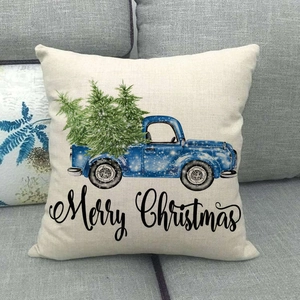 Close-up of linen Christmas pillow cover featuring a vintage blue truck design and Merry Christmas text