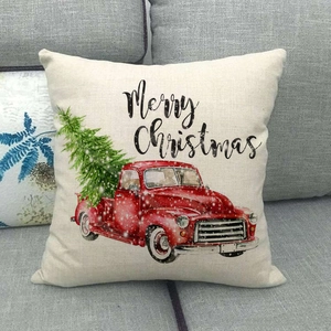 Close-up of linen pillow cover featuring a red vintage Christmas truck and Merry Christmas text