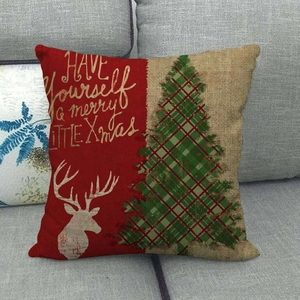 Funda de cojín de lino con reno de Navidad y diseño patchwork en un sofá gris claro