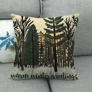 Détail de la housse de coussin en lin avec motif de forêt hivernale et texte chaud