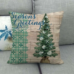 Détail de housse de coussin en lin avec sapin d'étoiles de mer et texte de fête