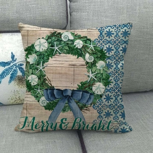 Détail de la housse de coussin de Noël en lin avec couronne marine sur un canapé