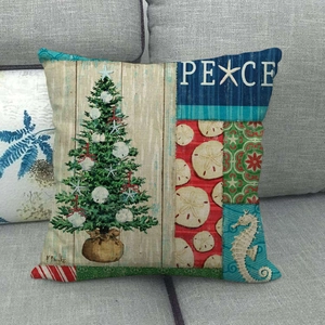 Détail de housse de coussin en lin de Noël avec sapin en coquillages et texte PEACE sur canapé
