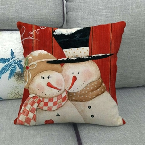 Housse de coussin Noël en lin rouge avec bonhomme de neige sur un canapé gris
