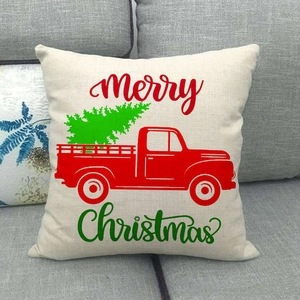 Linen Christmas pillow case with red truck and tree displayed on a grey sofa
