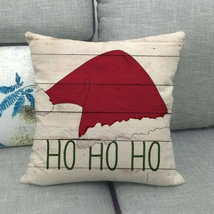 Federa per cuscino natalizia con stampa in legno e cappello di Babbo Natale su divano