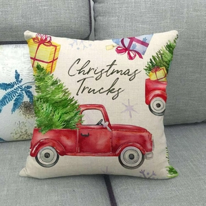 Detail of Christmas truck linen pillowcase on a grey sofa showing fabric texture