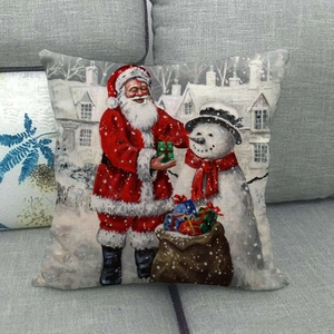 Funda de cojín navideña de lino con Papá Noel y muñeco de nieve en un sofá gris