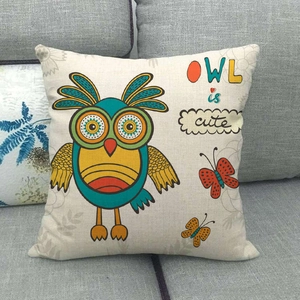 Détail de la housse de coussin en lin avec hibou sur un canapé gris élégant