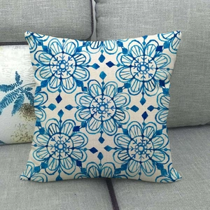 Linen decorative pillow cover with blue geometric floral pattern on a grey sofa