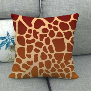 Macro detail of textured linen throw pillow case featuring orange giraffe pattern print