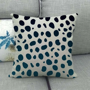 Close-up of linen pillowcase with blue irregular dots on a gray sofa fabric